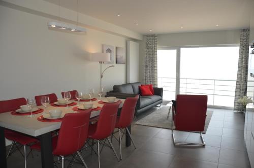 une salle à manger avec une table et des chaises rouges dans l'établissement 4B @ Longchamp, à Ostende