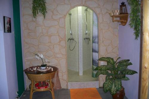 a bathroom with a shower and a table and a chair at Gasthof zum Döhlerwald in Klingenthal