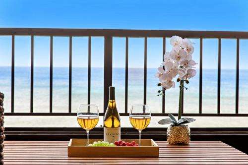 a table with two glasses of wine and a tray of food at Maui Kai 405 in Honokowai