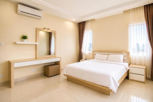 a bedroom with a large white bed and a mirror at Phnom Penh Star Apartment in Phnom Penh
