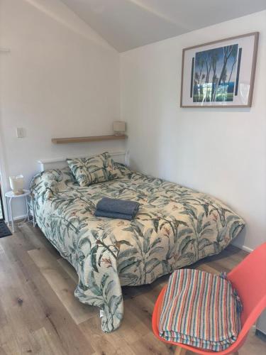 a bedroom with a bed and a chair at Mapua Cabbage Trees in Mapua
