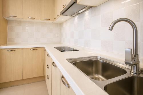 a kitchen with a sink and a stainless steel sink at Phnom Penh Star Apartment in Phnom Penh