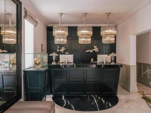 a bathroom with a black vanity and chandeliers at MiM Ibiza member of Meliá Collection in Ibiza Town