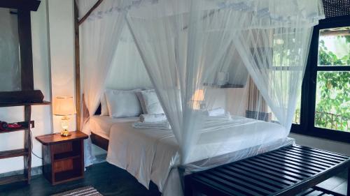 a bedroom with a bed with mosquito netting at Turn View Resort Ella in Ella