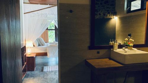 a bathroom with a sink and a bedroom with a bed at Turn View Resort Ella in Ella