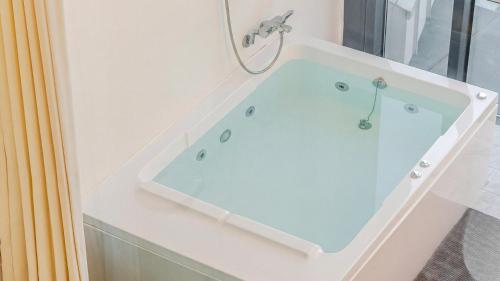 a bathroom with a bath tub with a sink at Gyeongju heybreeze Pool Villa in Gyeongju