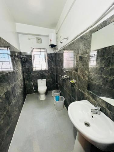 a bathroom with a sink and a toilet at HOTEL DAISY in Guwahati