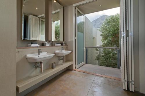 a bathroom with two sinks and a large window at Mosselberg on Grotto Beach in Hermanus