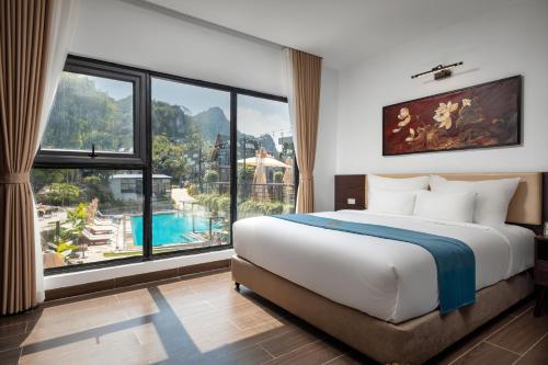 a bedroom with a large bed and a large window at Cát Bà Sena Valley Retreat in Xuan Dam
