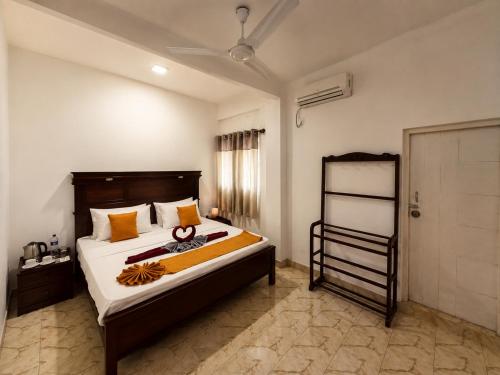 a bedroom with a large bed with a wooden headboard at Krautergarten Resort & Wellness in Negombo
