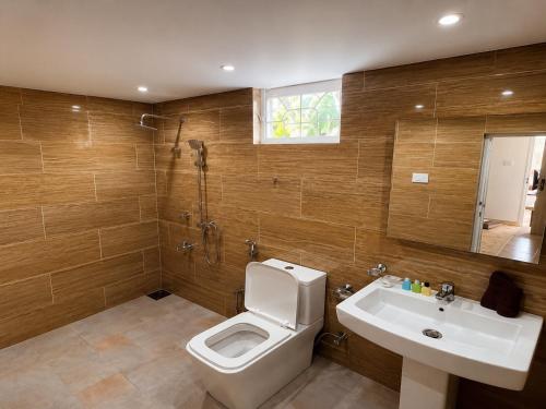 a bathroom with a toilet and a sink at Krautergarten Resort & Wellness in Negombo
