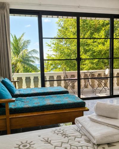 a room with two beds and a large window at Tea Moon Boutique Stay in Thong Sala
