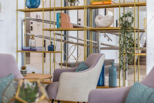 a room with two chairs and shelves with vases at Hotel Las Arenas, Affiliated by Meliá in Benalmádena