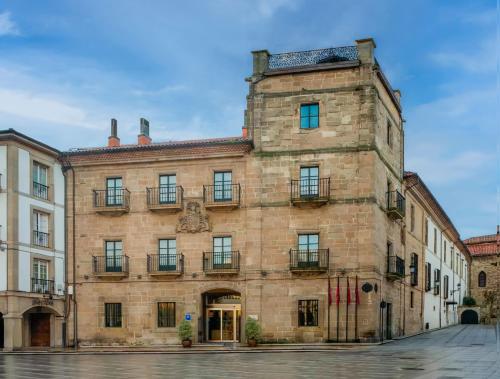 a large brick building with windows and balconies at Palacio de Avilés, Affiliated by Meliá in Avilés
