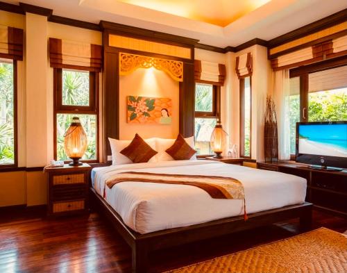 a bedroom with a large bed and a flat screen tv at Salad Buri Resort- SHA Extra Plus in Salad Beach