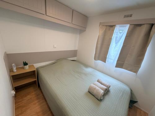 a bedroom with a bed with two towels on it at Mobile Home WT 1906 in Saint-Pierre-dʼOléron