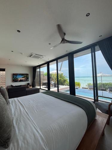 a bedroom with a bed and a view of the ocean at Villa Miario in Koh Samui