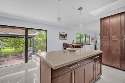 a kitchen with wooden cabinets and a large window at Modern Miami Oversized 3 Bedroom in Central Location in Miami
