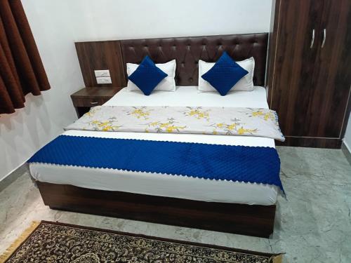 a bed with blue and white sheets and blue pillows at Hotel sphatic in Chitrakoot