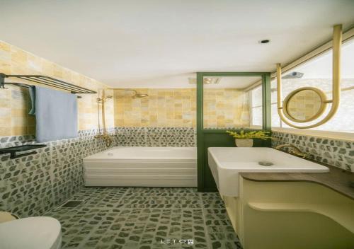 a bathroom with a tub and a toilet and a sink at Homestay Ecopark Hung Yen by QMP in HÆ°ng YÃªn