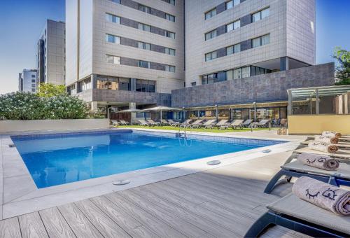 a swimming pool in front of a building at INNSiDE by Meliá Valencia Oceanic in Valencia
