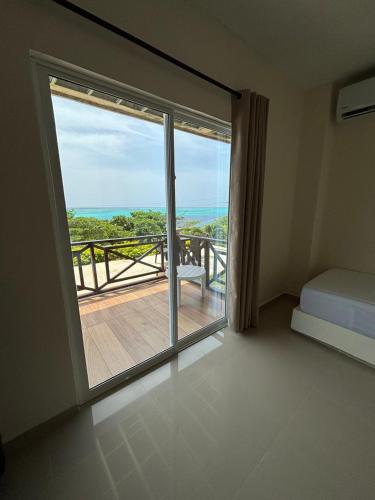 a bedroom with a large window and a view of the ocean at Ocean Inn- Sector el Bluff in Bottom House