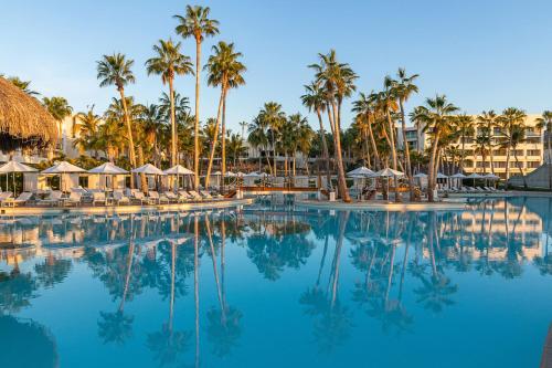 a swimming pool with palm trees and a hotel at Paradisus by Meliá Los Cabos - Adults Only - All Inclusive in San José del Cabo