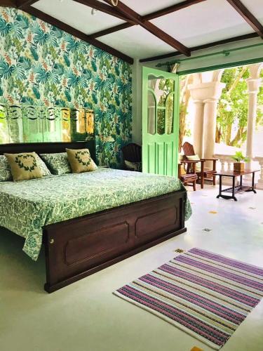a bedroom with a bed with a green bedspread at Boutique Villa with a Pool in Kandy