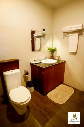 a bathroom with a toilet and a sink at Marabedda Gardens Resort in Rikillagaskada