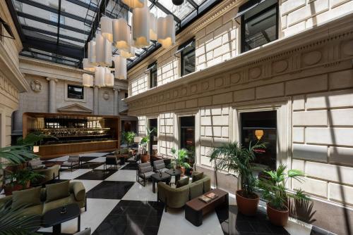 a lobby of a building with chairs and plants at Casa Lucia member of Meliá Collection in Buenos Aires