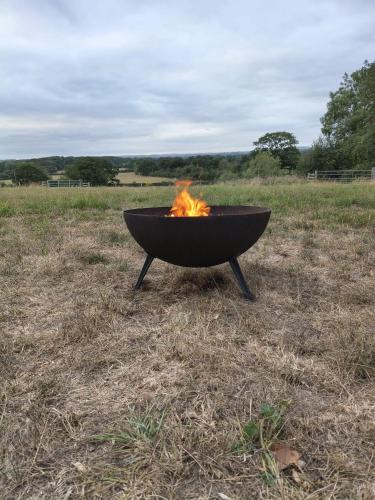 a fire pit sitting in the middle of a field at Hilltop Farm Camping in Haselbury Bryan