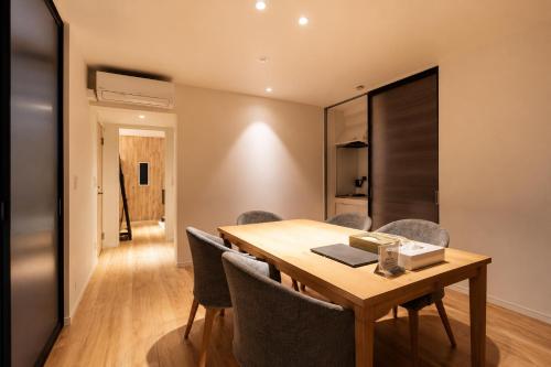 a dining room with a wooden table and chairs at 5 minutes Shin-Osaka 9 in Osaka