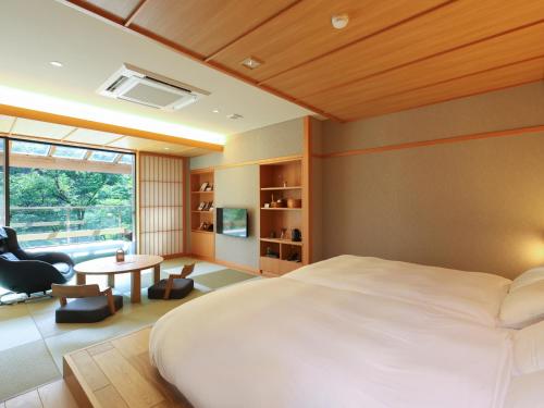 a bedroom with a large bed and a table at Keiryuso Siorie in Matsumoto