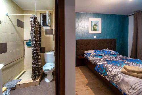 a bedroom with a bed and a bathroom with a toilet at Casa Dumitrescu in Năvodari