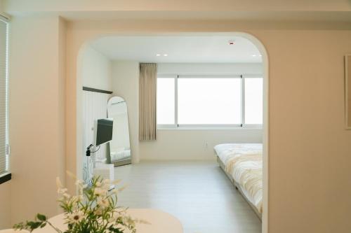 a bedroom with a bed and a mirror at 버터인 강릉역 중앙시장 월화거리 교리단길 도보 10분 in Gangneung