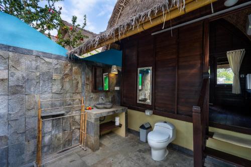a bathroom with a toilet and a sink at Dream Beach Kubu & SPA by ABM in Nusa Lembongan