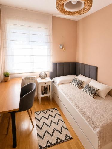 a bedroom with a bed and a table and a window at Piso acogedor con terraza in Ciudad Real