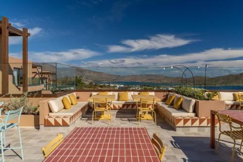 a patio with couches and tables and chairs at INNSiDE by Meliá Crete Elounda in Elounda