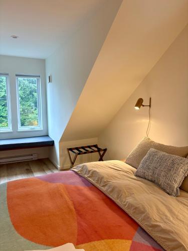 a bedroom with a bed with a lamp and a window at The Four Cedars in Ucluelet