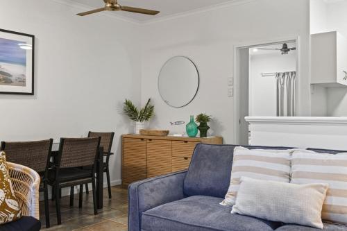 ein Wohnzimmer mit einem blauen Sofa und einem Tisch in der Unterkunft Shell Escape in Broome