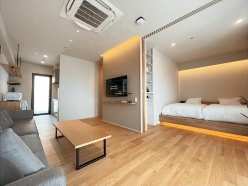 a bedroom with a bed and a table in a room at CONTEL BASE Tokyo in Tokyo