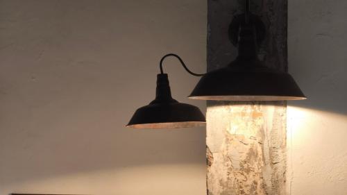two lights are hanging on a wall at Kosin House in Bangkok