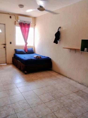 a bedroom with a bed with a red curtain and a window at Linda Vista Garden Cancun, Privado con AC y WiFi Cerca de Transporte a Zona Hotelera in Cancún
