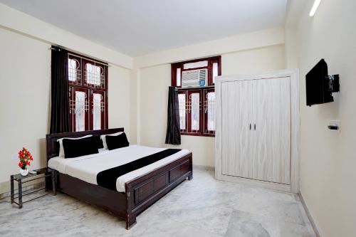 a bedroom with a bed and two windows at Hotel O Patel Nagar Patna Formerly Princess Home in Patna
