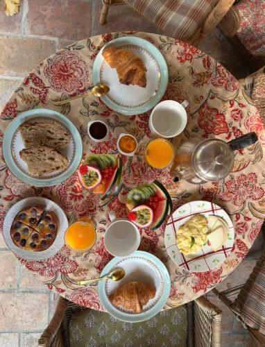 a table topped with plates of food and orange juice at Le Numéro 10 in Bernis