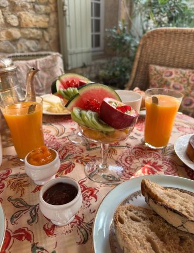 a table with a plate of food with bread and fruit at Le Numéro 10 in Bernis