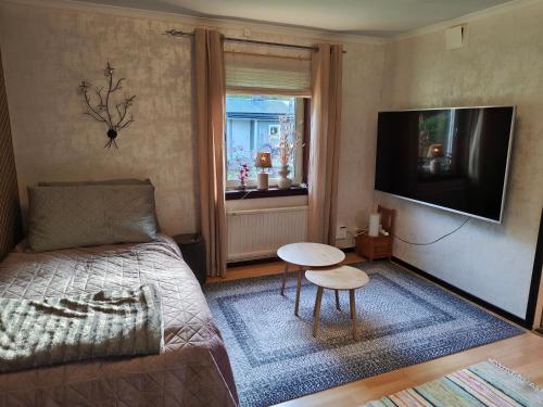 a bedroom with a bed and a table and a television at Muminhuset i Norberg in Norberg
