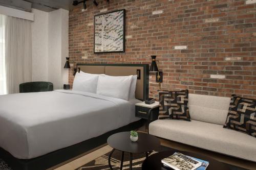 a bedroom with a large bed and a brick wall at The Livingston, part of JdV by Hyatt in Brooklyn