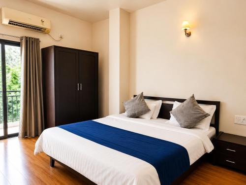 a bedroom with a large bed and a window at Hotel Maurya Regency in Morjim