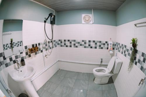 a bathroom with a toilet and a sink at แพ River Tale Uthaithani in Ban Khok Mo